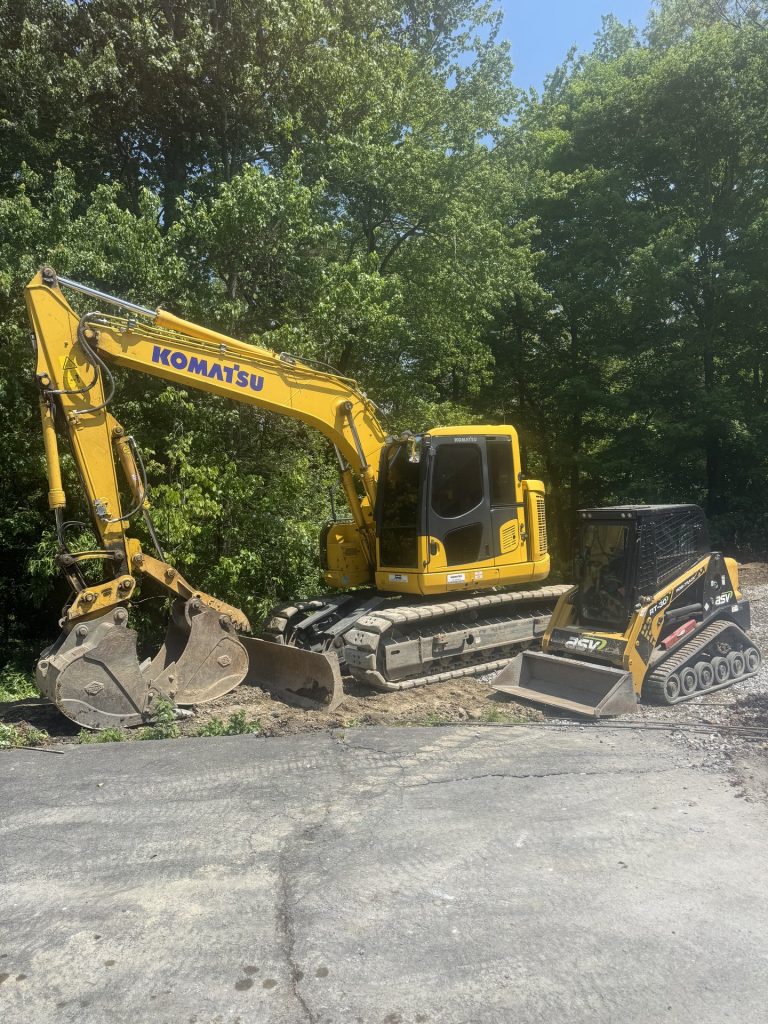 Komatsu excavator on a residential driveway grading job by Dutchess Lawns & Masonry